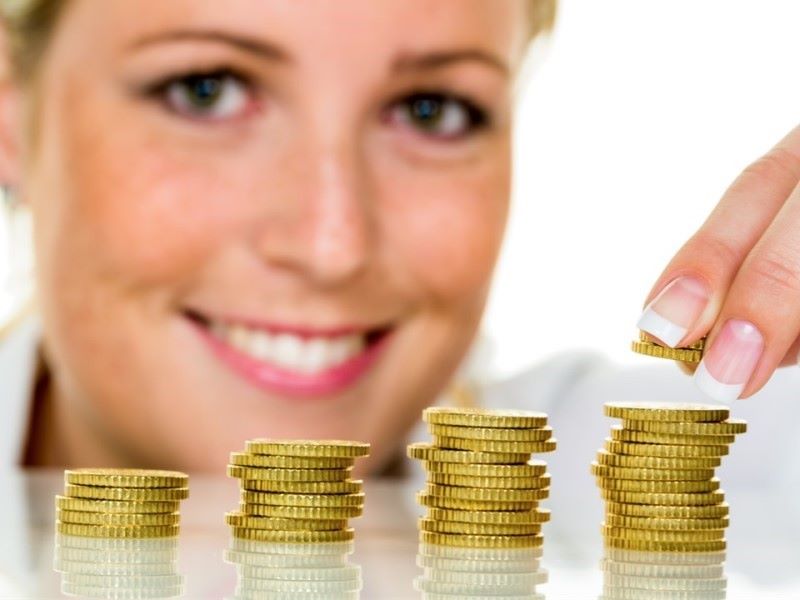 Ženski obraz, ki polaga kovance v štiri stolpce.