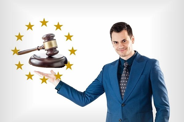  Poslovnež kaže na sodniško kladivo obdano z evropskimi zvezdicami.