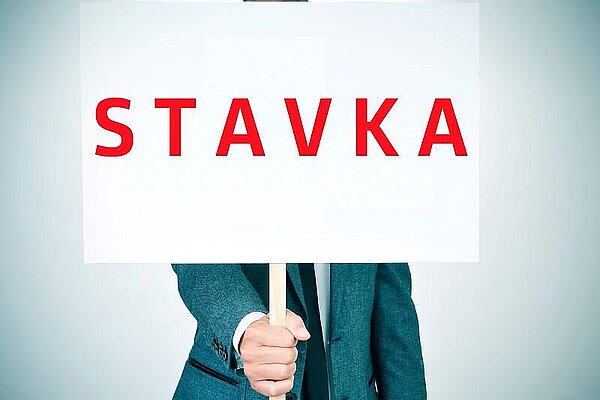  Uslužbenec drži v roki tablo z napisom STAVKA.